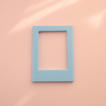 DIY Decoden customizable sky blue Polaroid loader frames with frosting-inspired glue, decorative sprinkles, charms, and magnets for personalizing your photos.