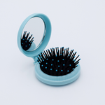 DIY Decoden customizable compact brush with mirror, adorned with charms and frosting-inspired glue, in pastel blue for easy touch-ups.