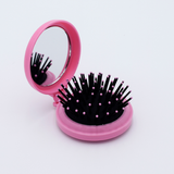 DIY Decoden customizable compact brush with mirror, adorned with charms and frosting-inspired glue, in deco pink for easy touch-ups.