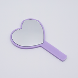 DIY Decoden customizable hand-held heart mirror in pastel purple with frosting-inspired glues, sprinkles, and charms, perfect for adding a personal touch to your routine.