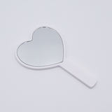 DIY Decoden customizable hand-held heart mirror in white with frosting-inspired glues, sprinkles, and charms, perfect for adding a personal touch to your routine.