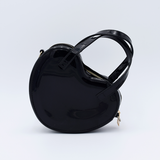 DIY Decoden customizable heart-shaped purse in black with frosting-inspired glues, decorative sprinkles, and charms, featuring a detachable gold cross-body chain.