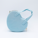 DIY Decoden customizable heart-shaped purse in pastel blue with frosting-inspired glues, decorative sprinkles, and charms, featuring a detachable gold cross-body chain.