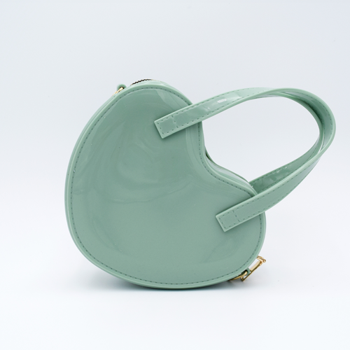 DIY Decoden customizable heart-shaped purse in pastel green with frosting-inspired glues, decorative sprinkles, and charms, featuring a detachable gold cross-body chain.