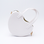 DIY Decoden customizable heart-shaped purse in white with frosting-inspired glues, decorative sprinkles, and charms, featuring a detachable gold cross-body chain.