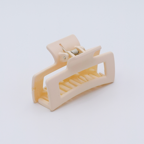 DIY Decoden customizable mini hair claw in cream, with frosting-inspired glue, decorative sprinkles, and charms, ready for decoration.