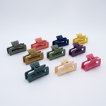 DIY Decoden customizable set of two mini hair claws, available in various colors, with frosting-inspired glue, decorative sprinkles, and charms, ready for decoration.