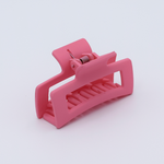 DIY Decoden customizable mini hair claw in pink, with frosting-inspired glue, decorative sprinkles, and charms, ready for decoration.