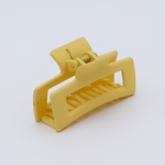 DIY Decoden customizable mini hair claw in soft yellow, with frosting-inspired glue, decorative sprinkles, and charms, ready for decoration.